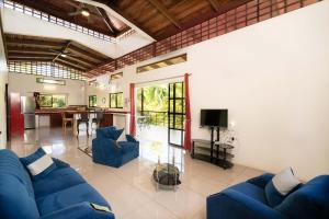 a living room with a blue couch and a table at Casa de las Palmas, Residencia Isabella in Parrita