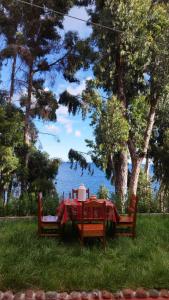 a table with a red table cloth and a hat on it at Illariywasi Homestay Comunidad Pueblo Isla Amantani in Amantani