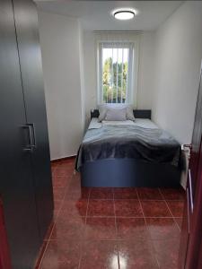 a small bedroom with a bed and a window at Virágos Lakás in Győr