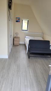 a bedroom with a bed and a wooden floor at Machaire Rabhartaigh Glamping in Mín Lárach
