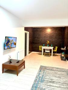 a living room with a table and yellow chairs at Residence 2 in Ploieşti +6 photos