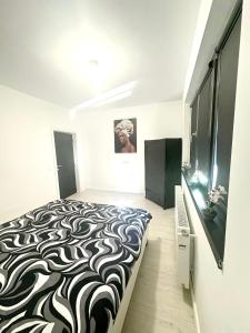 a bedroom with a black and white bed in a room at Residence 2 in Ploieşti