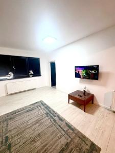 a living room with a tv and a table at Residence 2 in Ploieşti