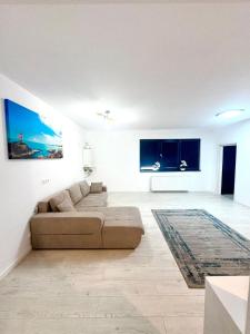 a white living room with a couch and a rug at Residence 2 in Ploieşti