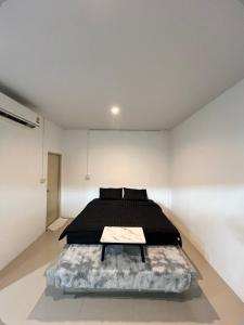 a bedroom with a black bed in a white room at The Retreat Hotel Wellness & Spa in Krabi