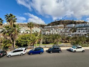a group of cars parked in a parking lot in front of a building at Miami Beach in Mogán