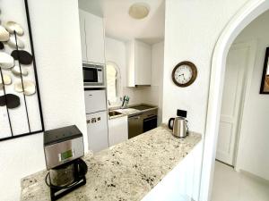 a kitchen with a counter and a clock on the wall at Miami Beach in Mogán