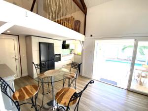 a kitchen with a table and chairs in a room at Villa TY'CREOLE in Saint-François