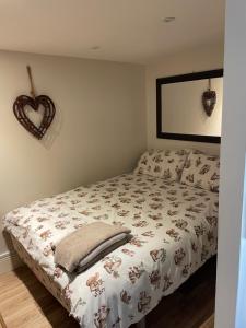 a bedroom with a bed with a heart decoration on the wall at Deer Lodge in Thornton Curtis