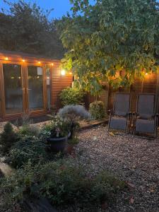 a yard with two chairs and a house at Deer Lodge in Thornton Curtis