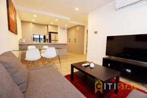 een woonkamer met een bank en een tafel bij Red Rose Retreat - 1bd 1bth 1CarSp Apt in Lyons