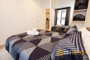 ein Schlafzimmer mit einem Bett mit einer schwarz-weißen Bettdecke in der Unterkunft Red Rose Retreat - 1bd 1bth 1CarSp Apt in Lyons