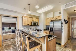 een keuken met een aanrecht met stoelen en een koelkast bij Silverado Getaway 124 condo in Park West Ski Area Heliport
