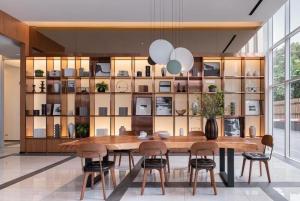 a dining room with a large wooden table and chairs at Urban Oasis BTS Ekkamai in Khlong Toei