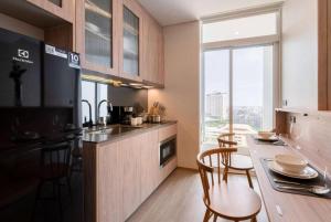a kitchen with a counter and a table with chairs at Urban Oasis BTS Ekkamai in Khlong Toei +6 photos