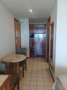 Habitación pequeña con mesa y nevera. en Flat Costa Mar, en Recife