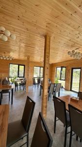 a dining room with wooden ceilings and tables and chairs at Sultan guesthouse in Chon-Oryuktyu