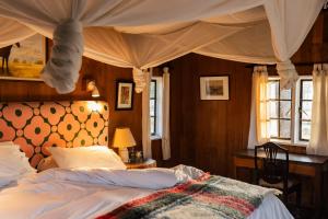 a bedroom with a bed with a canopy at Rose Cottage Romantic Cottage In Wildlife in Naivasha