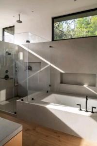 Un baño blanco con bañera y ducha. en Arsvile, en Maun