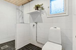 Un baño blanco con inodoro y ventana. en Cozy Lapland Hideaway, 2BDR, Wifi & Parking, en Rovaniemi