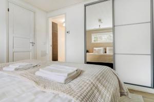 Un dormitorio blanco con una cama con toallas. en Cozy Lapland Hideaway, 2BDR, Wifi & Parking, en Rovaniemi