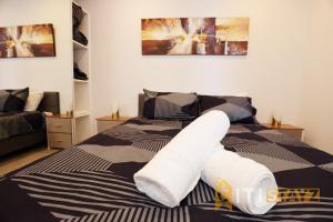 een slaapkamer met een bed met witte handdoeken bij Red Rose Retreat - 1bd 1bth 1CarSp Apt in Lyons