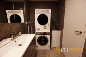 een badkamer met een wasmachine en droger naast een wastafel bij Red Rose Retreat - 1bd 1bth 1CarSp Apt in Lyons +29 foto's