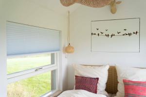 a bedroom with a window with birds on the wall at Studio Mini in Oersberg