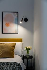 ナポリにあるPlebiscito Luxury Roomsのベッドとテーブルの上に花瓶が置かれた寝室