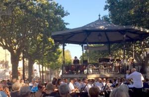 a crowd of people sitting in front of a band at Ground floor apartment in center in Mèze