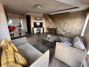 a living room with a couch and a table at Skyhouse Riga Relax Penthouse And Spa in Rīga