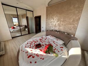 a bedroom with a bed with red flowers on it at Skyhouse Riga Relax Penthouse And Spa in Rīga