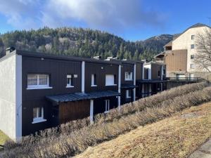 eine Reihe von Häusern auf einem Hügel mit einem Berg im Hintergrund in der Unterkunft Grand chalet mitoyen dans secteur calme et ensoleillé - FR-1-787-38 in Laveissière