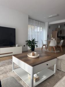 Una sala de estar con televisión y una mesa de café. en Rednitz Luxus House, en Rednitzhembach
