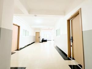an empty hallway in an office building with doors open at Golden Crystal Hotel in Accra +17 photos