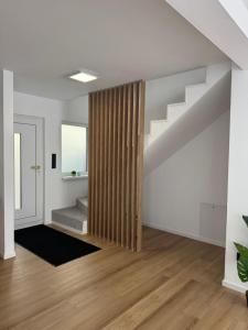 an empty living room with a stairway with a wooden curtain at Rednitz Luxus House in Rednitzhembach