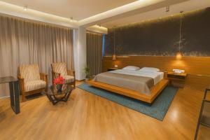 a hotel room with a bed and two chairs at Golden Palace Hotel in Tbilisi City