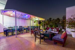 ニューデリーにあるJyoti Mahal - A Newly Renovated Heritage Hotel in the Centre of Delhi - Near New Railway Station & Connaught Placeのパティオ(テーブル、椅子、紫色の照明付)