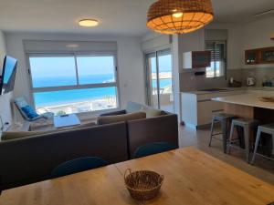 a living room and kitchen with a view of the ocean at Albi Boutique Apartments in ‘Akko