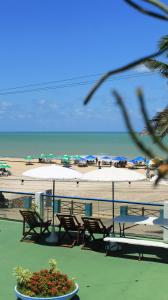a beach with tables and chairs and umbrellas at Ponta Negra Suites & Apart in Natal