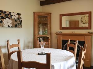a dining room with a table with a wine glass on it at Clematis Cottage in Burnsall
