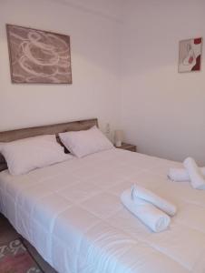 a white bed with two white towels on it at Misty Place in Ioannina