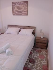 a bedroom with a large white bed and a night stand at Misty Place in Ioannina