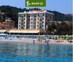 菲纳莱利古雷丽都公寓式酒店的一群人在靠近水边的海滩上