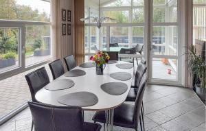 a dining room with a white table and chairs at Cozy Home In Tarm With Sauna in Højsand