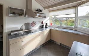 a kitchen with white cabinets and a sink at Cozy Home In Tarm With Sauna in Højsand