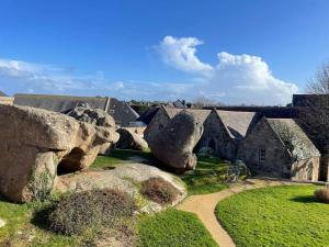 a group of rocks in front of a house at Maison rénovée proche plages de Trégastel - FR-1-542-68 in Trégastel