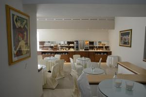 a dining room with white tables and white chairs at Albergo Italia in Matera