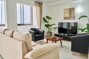 a living room with a couch and a tv at Buenavista Las Canteras in Las Palmas de Gran Canaria