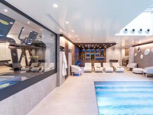 a room with a swimming pool and a gym at Novotel Deauville Plage in Deauville